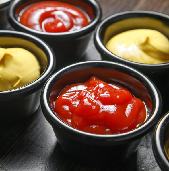 Small cups with ketchup and mustard